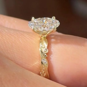 Peut inclure: Une bague en or avec une grande pierre précieuse transparente, ronde et facettée, montée sur quatre griffes. L'anneau en or jaune présente un motif complexe en relief rappelant une vigne, orné de petites pierres transparentes incrustées.