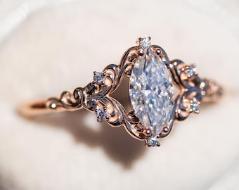 Anillo con diamante talla marquesa y banda de filigrana de estilo vintage en oro rosa, con delicado diseño floral.