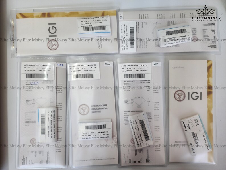 May include: A collection of IGI diamond grading reports and certificates in clear plastic sleeves. The reports feature barcodes, text, and the IGI logo. The certificates are in various sizes and shapes, with a gold and white color scheme.