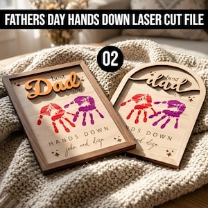 May include: Two wooden Father's Day plaques with handprint designs. One is rectangular, the other arched. Both feature the words "best Dad ever" and "HANDS DOWN" with the names "john and diza". The rectangular plaque has a brown frame.