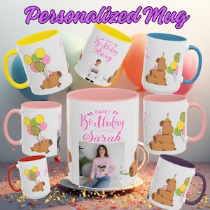 May include: White ceramic personalized birthday mugs with colorful accents. Designs include a capybara with balloons, a photo, and the text "Happy Birthday" with a name. The mugs have colored handles and interiors.