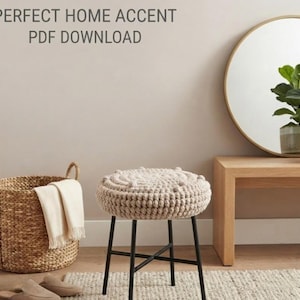 May include: A round stool with a beige crocheted seat featuring a textured bobble pattern and four thin black metal legs. The text PERFECT HOME ACCENT PDF DOWNLOAD is visible at the top. The stool is positioned near a woven basket and a wooden table.