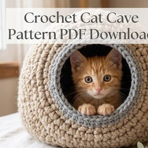May include: A beige crochet cat cave with a grey circular trim opening. An orange tabby kitten is sitting inside the structure. The text "Crochet Cat Cave Pattern PDF Download" is overlaid on the upper portion of the image.
