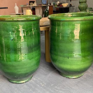 Może przedstawiać: Zestaw trzech ceramicznych kubków z nakrapianym, matowym wykończeniem. Kubki są w odcieniach kremu, jasnoszarym i ciemnoszarym. Każdy kubek ma prosty, minimalistyczny design.