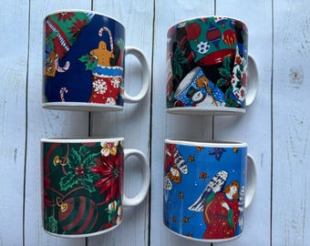 May include: Four ceramic mugs with white handles and rims. Each mug features a different Christmas-themed design. One has a gingerbread man and candy canes, another has ornaments and holly, and the others have angels and snowmen.