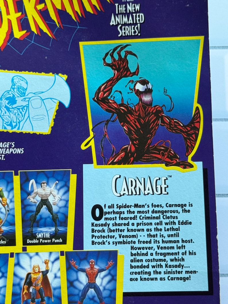May include: A toy package featuring the character Carnage from the Spider-Man animated series. The package has a purple background with images of other characters and text. The Carnage figure is red with black accents.