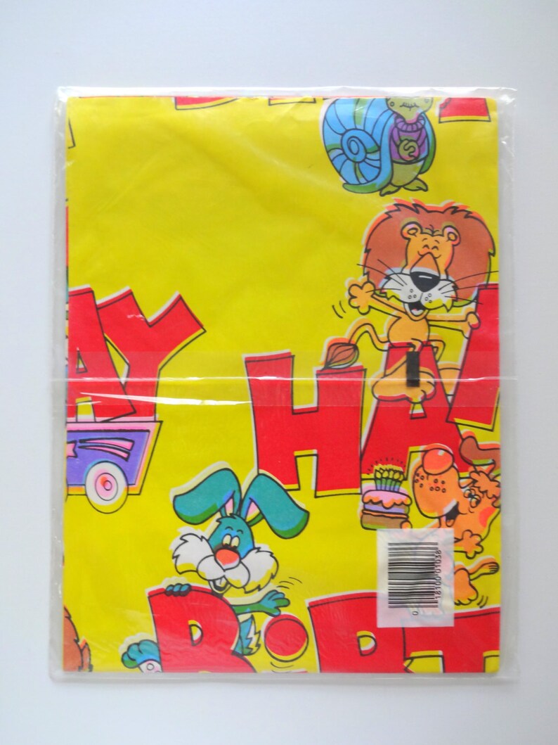 May include: Yellow wrapping paper with a colorful cartoon design. The paper features the words "Happy Birthday" in large red letters and various animals including a lion, a rabbit, and a snail.