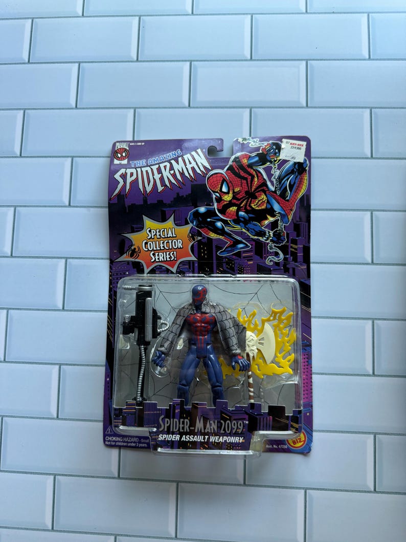 May include: A Spider-Man 2099 action figure in its original packaging. The figure is in a clear plastic case, with a red and blue costume, and a silver and yellow weapon. The packaging reads "The Amazing Spider-Man" and "Special Collector Series!"
