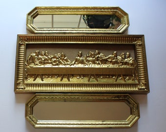 Könnte beinhalten: Ein goldgerahmtes Wandbild, das das Abendmahl darstellt. Das Kunstwerk verfügt über ein erhabenes, dreidimensionales Design und ist von einem dekorativen, verzierten Rahmen umgeben.