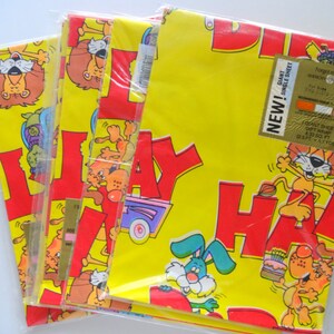 May include: Three rolls of yellow wrapping paper with a red "Happy Birthday" design featuring cartoon animals. The paper is labeled "Giant Single Sheet Gift Wrap 2.25 sq ft (0.21 sq m)".