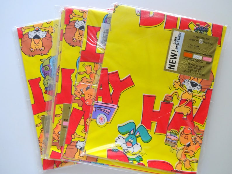 May include: Three rolls of yellow wrapping paper with a red "Happy Birthday" design featuring cartoon animals. The paper is labeled "Giant Single Sheet Gift Wrap 2.25 sq ft (0.21 sq m)".