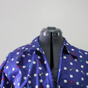 May include: A blue zip-up jacket with a golf ball and tee pattern.