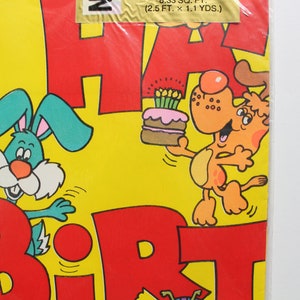 May include: A yellow, red, and green wrapping paper with a bunny and a dog holding a birthday cake. The paper says "Happy Birthday".