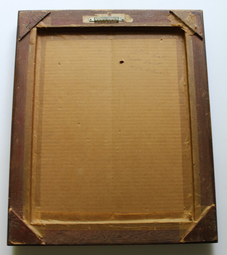 May include: A brown wooden frame with a cardboard backing. The back of the frame has handwritten text that reads "John List,  Built in 1937,  451 Oliver."