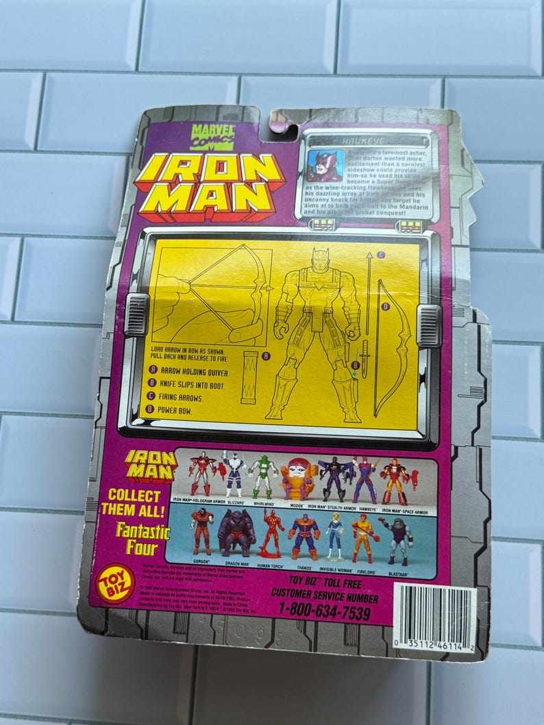 May include: The back of an Iron Man action figure package. The package features the Marvel Comics logo, the Iron Man logo, and a diagram of the figure's accessories. The package also includes a list of other figures to collect.
