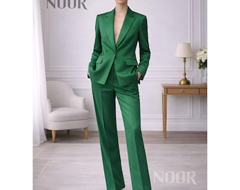 May include: A vibrant green suit, featuring a tailored blazer with pockets and matching wide-leg trousers. The suit is worn with white heels. The word "NOOR" is displayed in the upper left and lower right corners of the image.