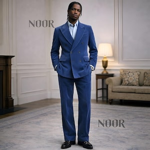 May include: A blue corduroy suit with a double-breasted jacket and matching trousers. The suit is worn with a light blue dress shirt and black dress shoes. The word "NOOR" is displayed in the image.