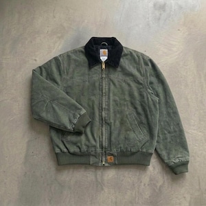 Puede incluir: Una chaqueta Carhartt de color verde salvia con cuello de pana negro, cremallera frontal completa y puños y dobladillo acanalados. La prenda incluye una pequeña etiqueta rectangular de la marca Carhartt en la parte inferior frontal.