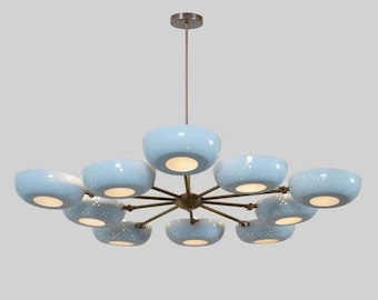 May include: A modern chandelier with a bronze finish and ten light blue, bowl-shaped shades. Each shade has a speckled pattern and emits a warm glow. The fixture is suspended from a single rod.