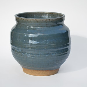光沢のある透明な青い釉薬を施した手作りの陶器のポット