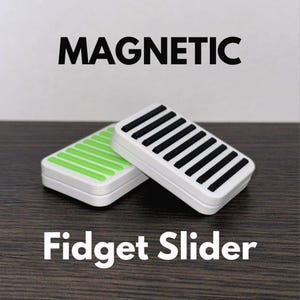 Op de afbeelding: Twee rechthoekige magnetische fidget-sliders met witte frames. Eén slider heeft parallelle zwarte ribbels op het oppervlak, terwijl de andere felgroene ribbels toont. De tekst "MAGNETIC" staat erboven en "Fidget Slider" staat eronder.