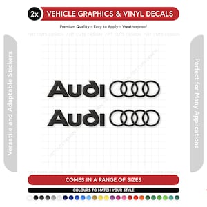 Puede incluir: Dos calcomanías de vinilo y gráficos para vehículos Audi negros. Las calcomanías presentan el logotipo de Audi, con el texto "Audi" y cuatro anillos entrelazados. La imagen también incluye el texto "Gráficos de vehículos y calcomanías de vinilo", "Viene en una gama de tamaños" y "Colores para combinar con tu estilo".