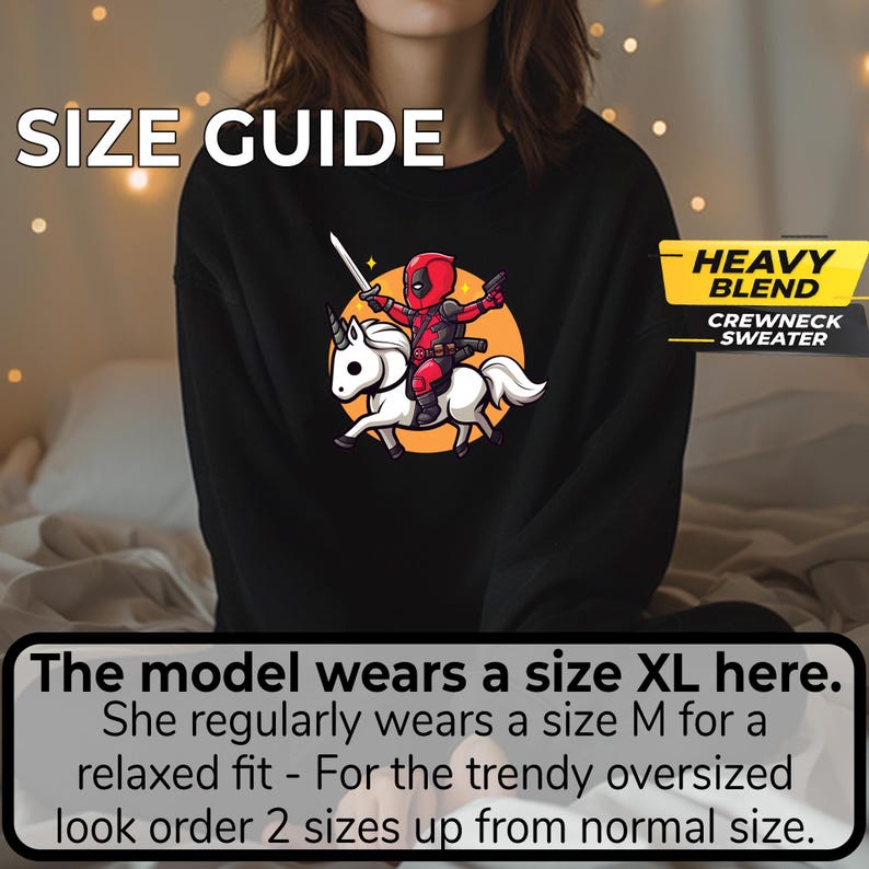 May include: Black crewneck sweater with a graphic of Deadpool riding a unicorn, set against an orange circle. The text "SIZE GUIDE" is at the top. The text "HEAVY BLEND CREWNECK SWEATER" is on the right.