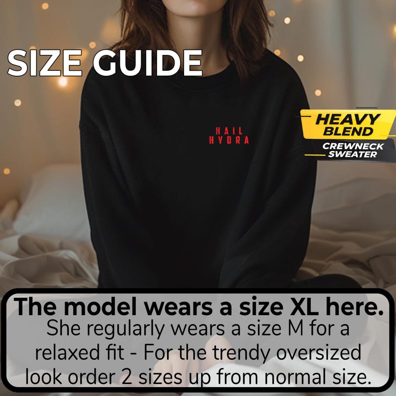 K&ouml;nnte beinhalten: Ein schwarzer Pullover mit Rundhalsausschnitt und dem roten Schriftzug HAIL HYDRA auf der Brust. Das Bild enth&auml;lt den Text SIZE GUIDE, HEAVY BLEND CREWNECK SWEATER und ein Feld mit der Aufschrift: The model wears a size XL here. She regularly wears a size M.