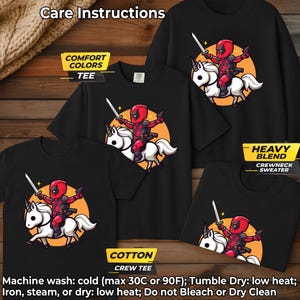 May include: Black t-shirts and a crewneck sweater featuring a cartoon Deadpool character riding a unicorn. The design includes a sword and an orange background. The image also displays care instructions and fabric type labels.