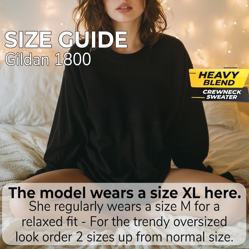 May include: A black crewneck sweater with long sleeves. Text on the image reads: SIZE GUIDE Gildan 1800, HEAVY BLEND CREWNECK SWEATER, The model wears a size XL here. She regularly wears a size M for a relaxed fit - For the trendy oversized look order 2 sizes up from normal size.