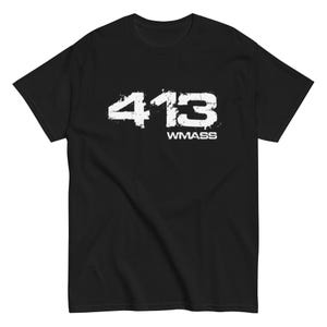May include: Black t-shirt with the white text "413 WMASS" printed on the front. The numbers and letters have a distressed, slightly blurred appearance. The shirt is a basic crew neck style.