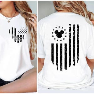 May include: White t-shirt featuring a black and white Mickey Mouse head design with the text "250 years of Freedom" on the front. The back of the shirt displays a distressed American flag design with a Mickey Mouse head and stars.