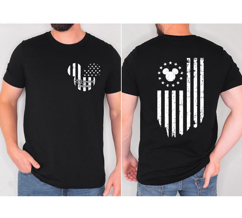 May include: Black t-shirt featuring a distressed American flag design with a Mickey Mouse silhouette. The front displays a Mickey head with flag elements and text. The back shows a flag design with a Mickey head and stars.