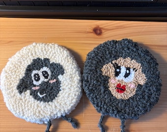 Set di 2 sottobicchieri a forma di pecora realizzati con la tecnica punch needle, in filato di cotone e lana, per decorazioni domestiche.