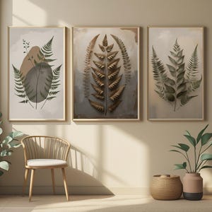 Puede incluir: Tres láminas artísticas botánicas enmarcadas con diseños de helechos. Las láminas tienen una paleta de colores neutros con tonos verdes, marrones y beige. La obra de arte se exhibe en una habitación bien iluminada con una silla y una cesta decorativa.