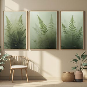 Peut inclure: Trois impressions encadrées représentant des frondes de fougères vertes dans un cadre forestier brumeux. L'œuvre d'art a un thème botanique naturel, avec une palette de couleurs douces et sourdes. Les cadres sont de couleur bois clair.