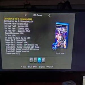 Może przedstawiać: Zrzut ekranu z menu konsoli do gier wideo wyświetlający listę gier, w tym "Dot Hack G.U. Vol. 2 - Reminisce (USA)". Niebieskie pudełko z grą z tytułem "hack G.U." jest widoczne po prawej stronie ekranu.