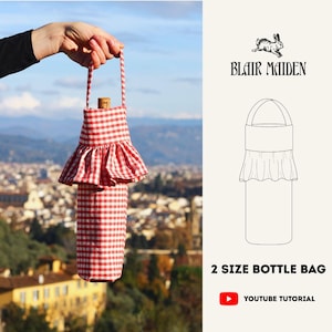 May include: A red and white checkered bottle bag with a ruffled skirt design, held up against a blurred cityscape. The bag has a handle and a cork stopper. The text "Blair Maiden" and "2 SIZE BOTTLE BAG" are also visible.
