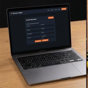May include: A laptop and tablet displaying digital invoice information. The laptop shows an invoice generator interface. The tablet displays a completed invoice. A yellow tape measure and a cup of coffee are on the wooden surface.