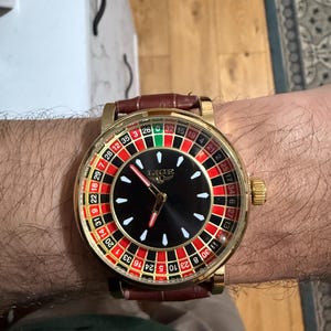 May include: A set of three ceramic mugs with a speckled, matte finish. The mugs are in shades of cream, light gray, and dark gray. Each mug has a simple, minimalist design and a rounded handle.