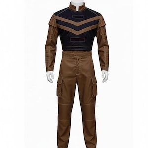 Puede incluir: Un disfraz de dos piezas con una parte superior marr&oacute;n y negra y pantalones marrones a juego. La parte superior tiene un cuello alto y un dise&ntilde;o de cheur&oacute;n. Los pantalones tienen bolsillos de carga. El atuendo se muestra en un maniqu&iacute;.