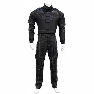 May include: A black tactical jumpsuit displayed on a mannequin. The outfit features a high collar, long sleeves, and pants with white stitching. The top has geometric patches, and the pants have reinforced knee and pocket areas. The jumpsuit is designed for a close fit.