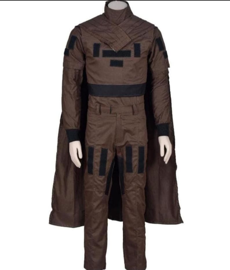 May include: A brown costume with a high collar, black accents, and a cape. The outfit includes a jacket with black patches, matching pants, and a black belt. The costume is displayed on a mannequin.
