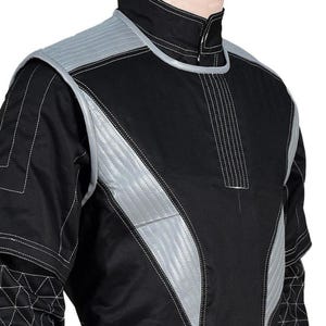 May include: Black jacket with silver accents and white stitching. The jacket features a high collar and quilted shoulder and chest panels. The design includes geometric patterns on the sleeves, creating a futuristic aesthetic.