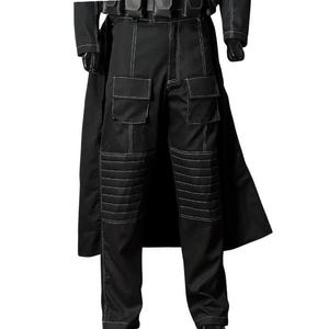May include: Black tactical trousers with white stitching. The trousers have multiple pockets and reinforced knee panels. A black coat is visible in the background. The trousers are part of a costume or uniform.