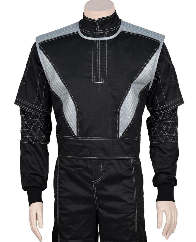 May include: Black racing suit with silver accents on the shoulders and chest. The suit has a high collar and white stitching details. The sleeves have geometric patterns near the cuffs. The suit is designed for motorsports.