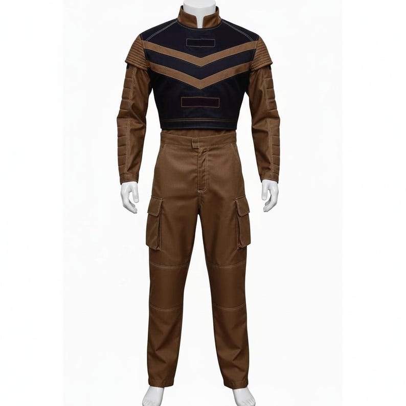 Puede incluir: Un disfraz de dos piezas con una parte superior marr&oacute;n y negra y pantalones marrones a juego. La parte superior tiene un cuello alto y un dise&ntilde;o de cheur&oacute;n. Los pantalones tienen bolsillos de carga. El atuendo se muestra en un maniqu&iacute;.