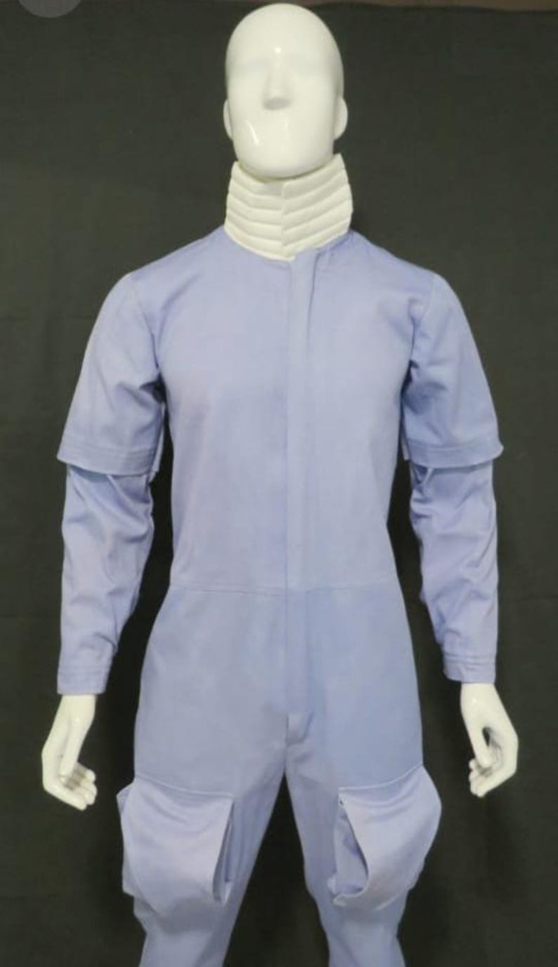 Puede incluir: Mono azul claro con cuello blanco acanalado. El mono tiene mangas largas con pu&ntilde;os desmontables, cremallera frontal y bolsillos grandes en los muslos. La prenda se exhibe en un maniqu&iacute;.