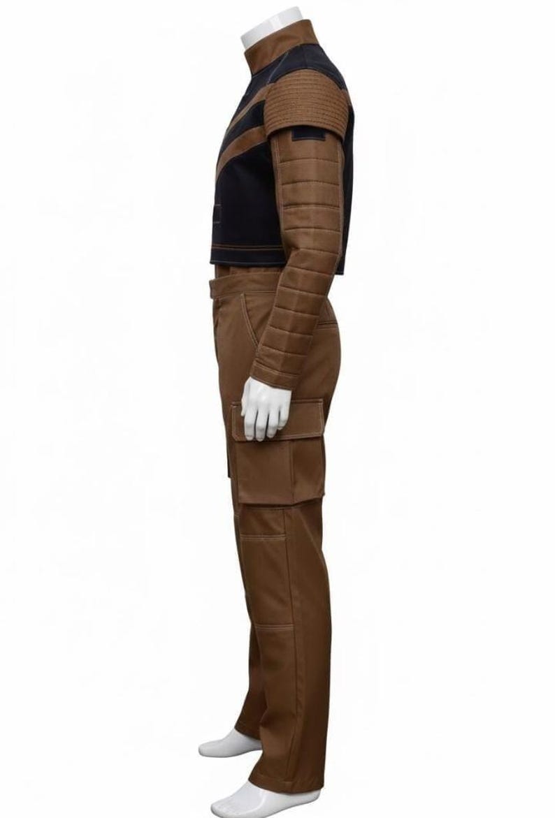 Puede incluir: Un disfraz marr&oacute;n y negro con una chaqueta corta con hombros y mangas acolchadas, combinada con pantalones cargo a juego. La chaqueta tiene un cuello alto y un panel negro en contraste. Los pantalones tienen bolsillos grandes.