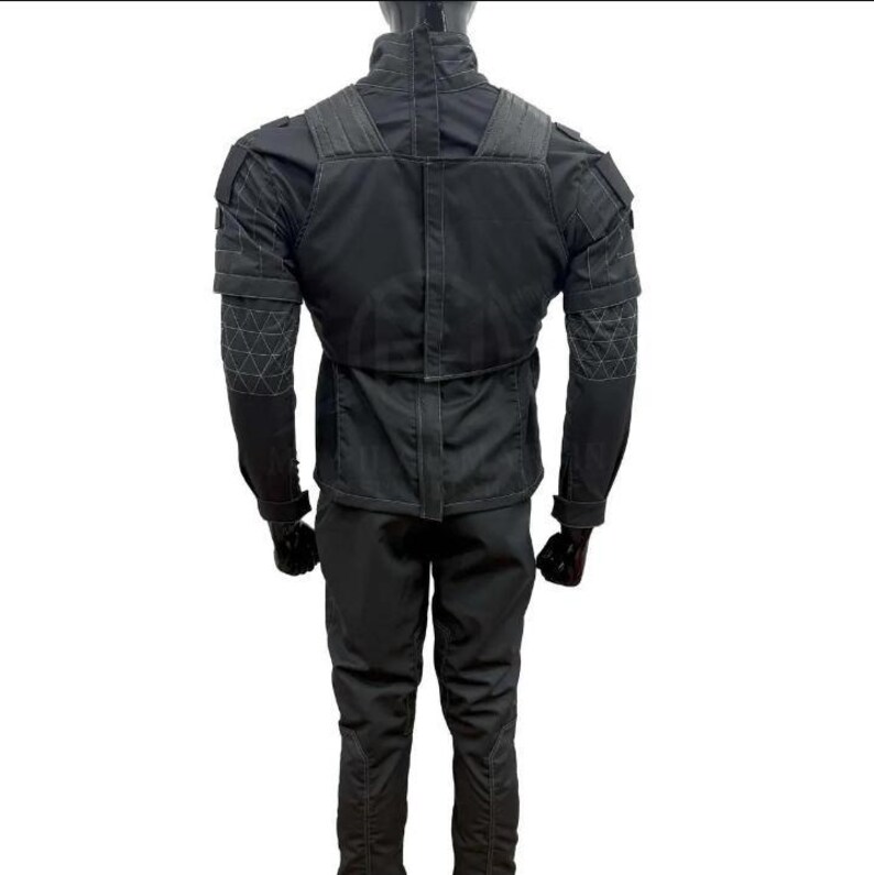 May include: A black tactical jacket and pants set. The jacket features reinforced shoulder and elbow patches, with a high collar and multiple pockets. The pants have a slim fit. The outfit is designed for durability and functionality.